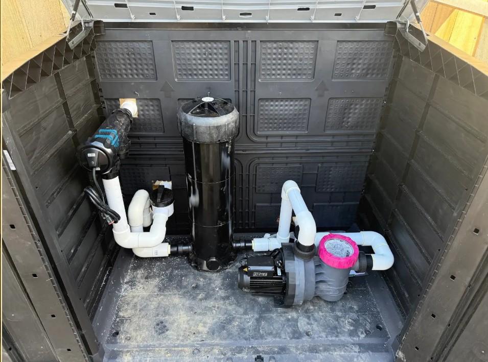 Pool pump and cartridge filter installed inside a compact pre-made equipment shed