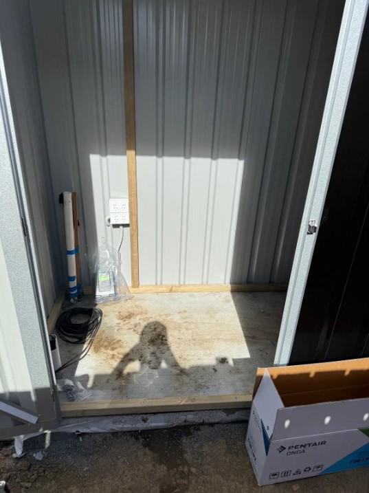 Empty pump shed before Opulent Pools installed the pool's filtration and chlorination plumbing