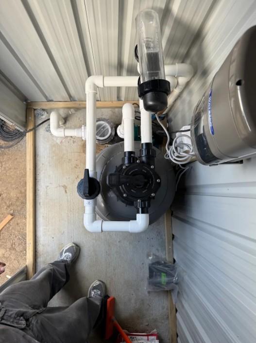 Overhead view of the newly plumbed pool filter, pump, and salt chlorinator installation